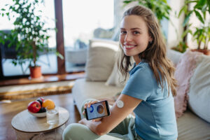 Young woman checking her blood sugar using rtCGM technology